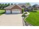 Beautiful brick home featuring a three-car garage, manicured lawn, and appealing landscaping at 6077 W David Wayne Dr, New Palestine, IN 46163