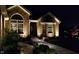 Beautiful brick home exterior with elegant landscaping and walkway lighting at night at 6077 W David Wayne Dr, New Palestine, IN 46163