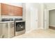 Laundry room features front load washer, dryer, and wooden upper cabinets at 6077 W David Wayne Dr, New Palestine, IN 46163
