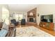 Cozy living room featuring a brick fireplace, hardwood floors, and comfortable seating at 6077 W David Wayne Dr, New Palestine, IN 46163