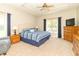 Bright main bedroom featuring a tray ceiling, ceiling fan, and large windows for natural light at 6077 W David Wayne Dr, New Palestine, IN 46163