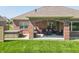 Covered brick patio with hot tub and outdoor furniture at 6077 W David Wayne Dr, New Palestine, IN 46163