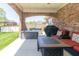 Covered patio with brick archways features outdoor furniture and a grill, ideal for entertaining at 6077 W David Wayne Dr, New Palestine, IN 46163