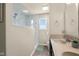 Bathroom featuring glass shower, ceramic sink with tile, and a large window offering natural light and modern design at 6096 E Conestoga Trl, Columbus, IN 47203