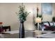 Dining table centerpiece, lamp, and a glimpse into the living area and sofa at 6096 E Conestoga Trl, Columbus, IN 47203