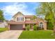 Charming two-story home featuring a well-maintained lawn and inviting front entrance with brick and vinyl siding at 6096 E Conestoga Trl, Columbus, IN 47203