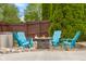 Outdoor area with blue Adirondack chairs surrounding a stone gas fire pit and greenery at 6096 E Conestoga Trl, Columbus, IN 47203