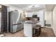 Bright kitchen with stainless steel refrigerator, island with seating, and views to the pool area at 6096 E Conestoga Trl, Columbus, IN 47203