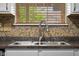 Close-up of a kitchen sink with a modern faucet and decorative tile backsplash at 6096 E Conestoga Trl, Columbus, IN 47203