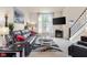 Cozy living room with leather seating, a mounted TV, and staircase leading to the second floor at 6096 E Conestoga Trl, Columbus, IN 47203