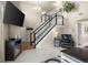 Living room featuring staircase, a large mounted TV, and neutral-toned decor at 6096 E Conestoga Trl, Columbus, IN 47203