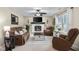 Inviting living room featuring a white-painted fireplace, ceiling fan, and plush brown seating at 6096 E Conestoga Trl, Columbus, IN 47203