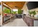 Entertain with style in this outdoor kitchen with ceiling fan, covered area, sink, and bar at 6096 E Conestoga Trl, Columbus, IN 47203
