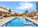 A backyard with a sparkling in-ground pool with slide, playset, and outdoor seating areas at 6096 E Conestoga Trl, Columbus, IN 47203