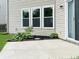 Concrete patio area featuring a sliding door, lush landscaping and a view of the home's exterior at 625 Streamside Dr, Greenfield, IN 46140