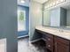 Bathroom with modern vanity, sink, and window, featuring a dark plank floor at 625 Streamside Dr, Greenfield, IN 46140