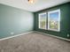 Cozy bedroom with carpet, green walls, two windows with blinds that offer natural light, and a closet at 625 Streamside Dr, Greenfield, IN 46140