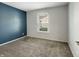 Well-lit bedroom with a window, blue accent wall, and plush carpeting, creating a cozy space at 625 Streamside Dr, Greenfield, IN 46140