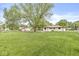 Spacious backyard with lush green grass, beautiful trees, and a charming single-story house at 645 W Stop 11 Rd, Indianapolis, IN 46217