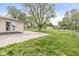 A spacious backyard features a concrete patio, grassy area, and mature trees with a charming exterior at 645 W Stop 11 Rd, Indianapolis, IN 46217