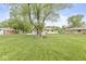Expansive backyard features lush green grass, mature trees and a charming single-story home at 645 W Stop 11 Rd, Indianapolis, IN 46217