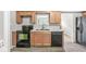 Well-equipped kitchen featuring wood cabinets, a black stove and dishwasher, and luxury vinyl plank flooring at 645 W Stop 11 Rd, Indianapolis, IN 46217