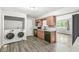 Combined laundry room and kitchen with modern appliances and new luxury vinyl plank flooring at 645 W Stop 11 Rd, Indianapolis, IN 46217