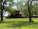 View of the house and backyard featuring a deck and mature trees offering privacy and charm at 7140 N Michigan Rd, Fairland, IN 46126