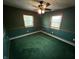 Cozy bedroom featuring a ceiling fan, classic wood trim, and lush green carpet to maximize comfort at 7140 N Michigan Rd, Fairland, IN 46126