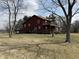 Two-story home with a wraparound deck in a large yard surrounded by trees at 7140 N Michigan Rd, Fairland, IN 46126