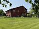 Exterior view of the house featuring a spacious lawn, deck and garage in the back at 7140 N Michigan Rd, Fairland, IN 46126