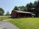 Exterior view of the house with a separate garage and a well-maintained lawn, complemented by green landscape at 7140 N Michigan Rd, Fairland, IN 46126