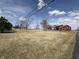 Property with a large yard and a red house in the distance under a bright sky at 7140 N Michigan Rd, Fairland, IN 46126
