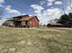 Spacious red house with a wraparound deck and a detached outbuilding in the background at 7140 N Michigan Rd, Fairland, IN 46126