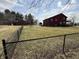 View of two-story home with red siding, and black chain link fence at 7140 N Michigan Rd, Fairland, IN 46126