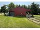 Outbuilding with a green roof and garage door on a large, well-maintained lawn at 7140 N Michigan Rd, Fairland, IN 46126
