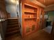 Living room featuring stairs, custom wooden shelving and door to the bathroom at 7140 N Michigan Rd, Fairland, IN 46126