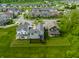 A neighborhood aerial shot showcases well-maintained homes and lush green spaces, offering a serene suburban setting at 7218 Antiquity Dr, Carmel, IN 46033