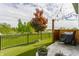 Landscaped backyard with artificial grass, iron fence, patio with Traeger grill, and view of trees and sky at 7218 Antiquity Dr, Carmel, IN 46033