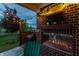 Evening backyard with patio, fireplace, Traeger grill and turf, illuminated by string lights at 7218 Antiquity Dr, Carmel, IN 46033