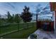 Backyard with artificial turf, fireplace, patio, Traeger grill and evening sky at 7218 Antiquity Dr, Carmel, IN 46033
