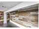Rustic basement accent wall with white trim and view to bonus area at 7218 Antiquity Dr, Carmel, IN 46033