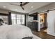 Bedroom with a mounted television, an open barn door to the bathroom, and dark wood flooring at 7218 Antiquity Dr, Carmel, IN 46033
