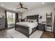 Well-lit bedroom featuring a ceiling fan, a decorative wall, and wood-look flooring at 7218 Antiquity Dr, Carmel, IN 46033