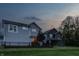 Exterior shot of a home at dusk, featuring a fenced backyard and a well-maintained lawn, perfect for evening relaxation at 7218 Antiquity Dr, Carmel, IN 46033