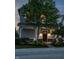 Charming two-story home with a welcoming front porch and well-manicured lawn at dusk at 7218 Antiquity Dr, Carmel, IN 46033