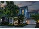 Charming two-story home featuring a covered front porch, attached garage, and well-manicured lawn at dusk at 7218 Antiquity Dr, Carmel, IN 46033