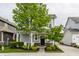 Charming two-story home featuring a covered front porch, attached garage, and well-manicured lawn at 7218 Antiquity Dr, Carmel, IN 46033