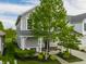 Beautiful two-story home with a covered porch, American flag, lush landscaping, and a convenient driveway at 7218 Antiquity Dr, Carmel, IN 46033