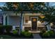 Inviting front porch with seating, a black front door, and lush landscaping at 7218 Antiquity Dr, Carmel, IN 46033